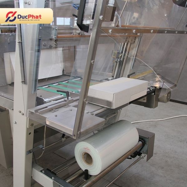 Máy co màng thực hiện công đoạn bọc và co màng sản phẩm Máy co màng thực hiện công đoạn bọc và co màng sản phẩm
