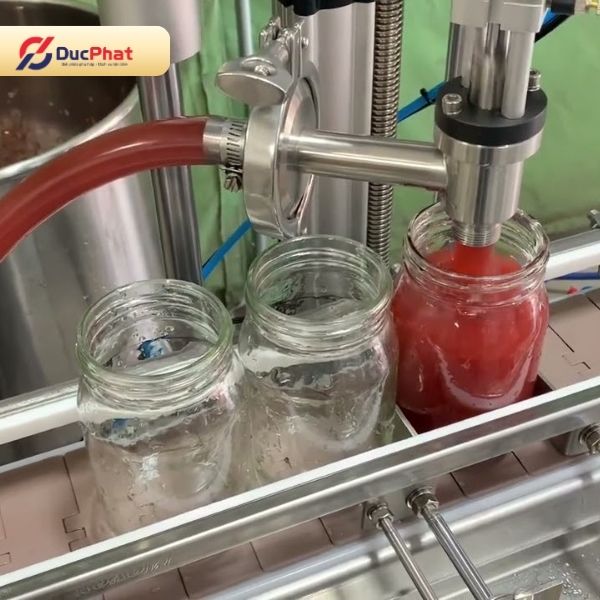 Máy chiết rót dung dịch vào hũ sử dụng hệ thống băng tải để đưa hũ đến vị trí chiết Máy chiết rót dung dịch vào hũ sử dụng hệ thống băng tải để đưa hũ đến vị trí chiết