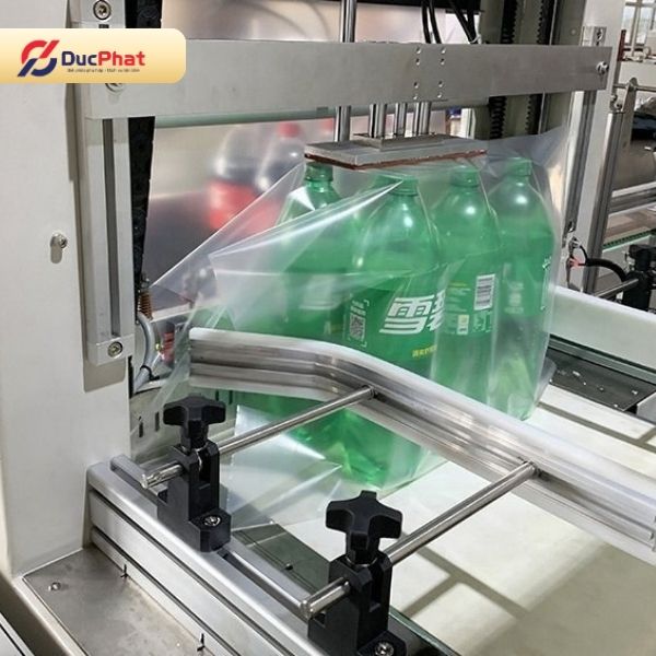 Các chai nước ngọt được bao màng để gom thành lốc gọn gàng trước khi co nhiệt Các chai nước ngọt được bao màng để gom thành lốc gọn gàng trước khi co nhiệt